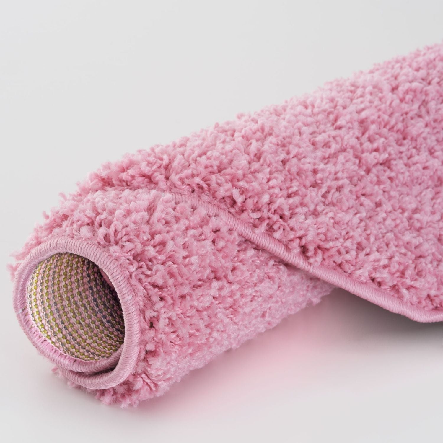 Pink plush fuzzy bath mat with soft texture and woven mesh backing from myshaggy solid pink rug collection