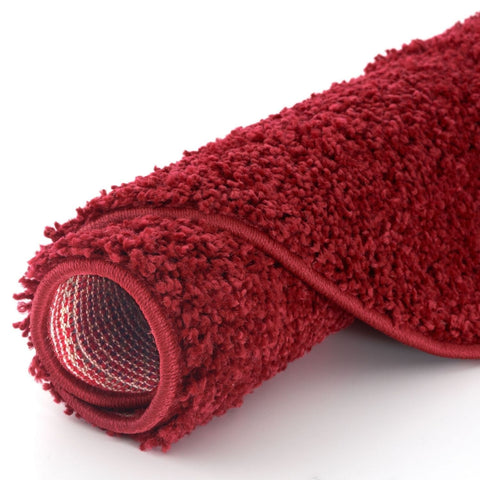 A plush myshaggy solid red rug with a soft shaggy texture and woven pattern on the back side