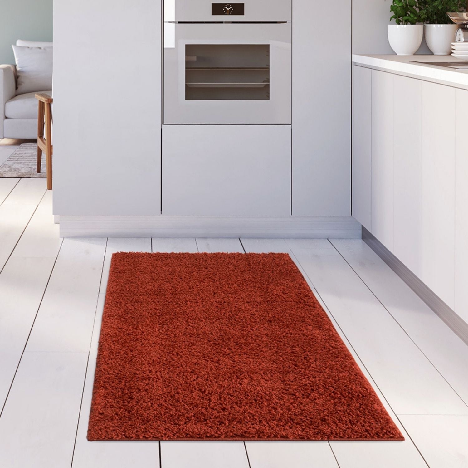 A plush rust-colored myshaggy solid terra rug with soft shaggy texture on a white wooden floor