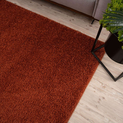 A plush rust-colored shag rug with dense soft texture perfect for cozy spaces myshaggy solid terra rug