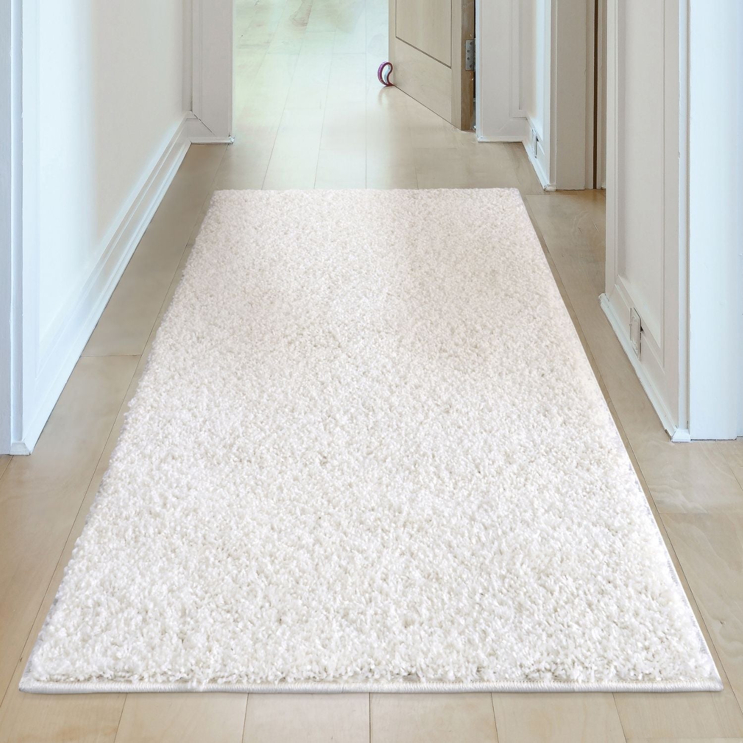 A plush myshaggy solid white shaggy area rug with soft textured surface and neatly finished edges