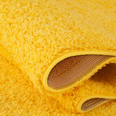 Myshaggy solid yellow plush shaggy bath mat with soft texture and visible woven backing as a solid yellow rug