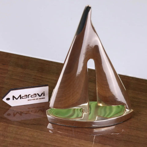 Shiny solid brass yacht model ornament with metallic sailboat and green swirled base branded maravi nabha brass yacht