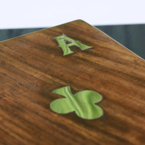 A wooden playing card with a green inlaid a and shamrock design in the Nadu double wooden playing card box