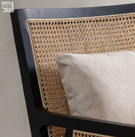 Nagoya rattan arm chair with black frame and light beige cushion featuring a stylish cane design