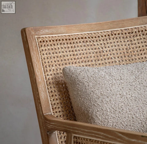 A light gray textured throw pillow resting on a natural black nagoya rattan arm chair with wooden frame