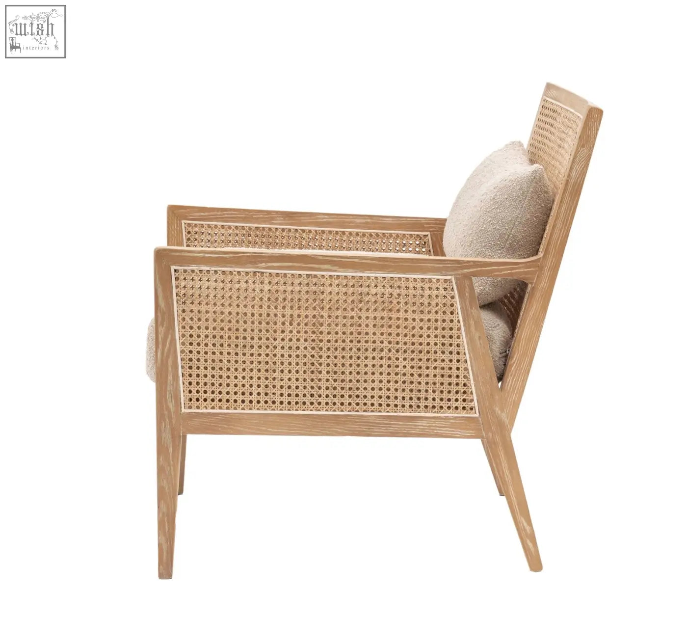 A nagoya rattan arm chair with light wood frame, woven cane back and seat, and a soft beige cushion in natural black