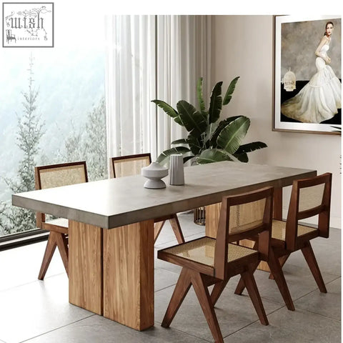 Modern concrete-top nakamura dining table with wooden legs and matching cane-backed chairs for dining rooms