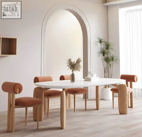 White oval namie dining table with light wood legs and matching terracotta upholstered chairs for cozy dining