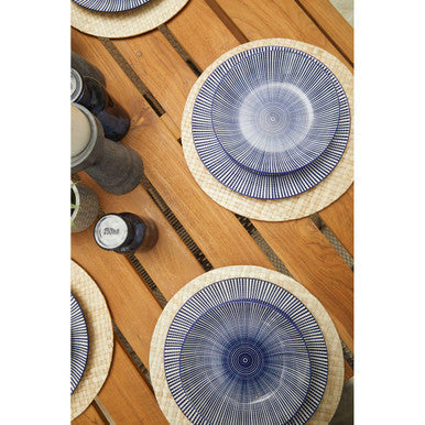 Set of three blue ceramic plates on natural placemats on nandri slatted teak wood dining table for wood dining table use