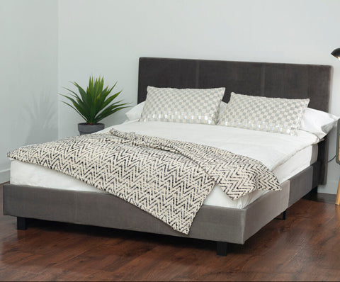 Gray upholstered napoli grey king bed with dark gray headboard footboard white bedding and black and white zigzag throw