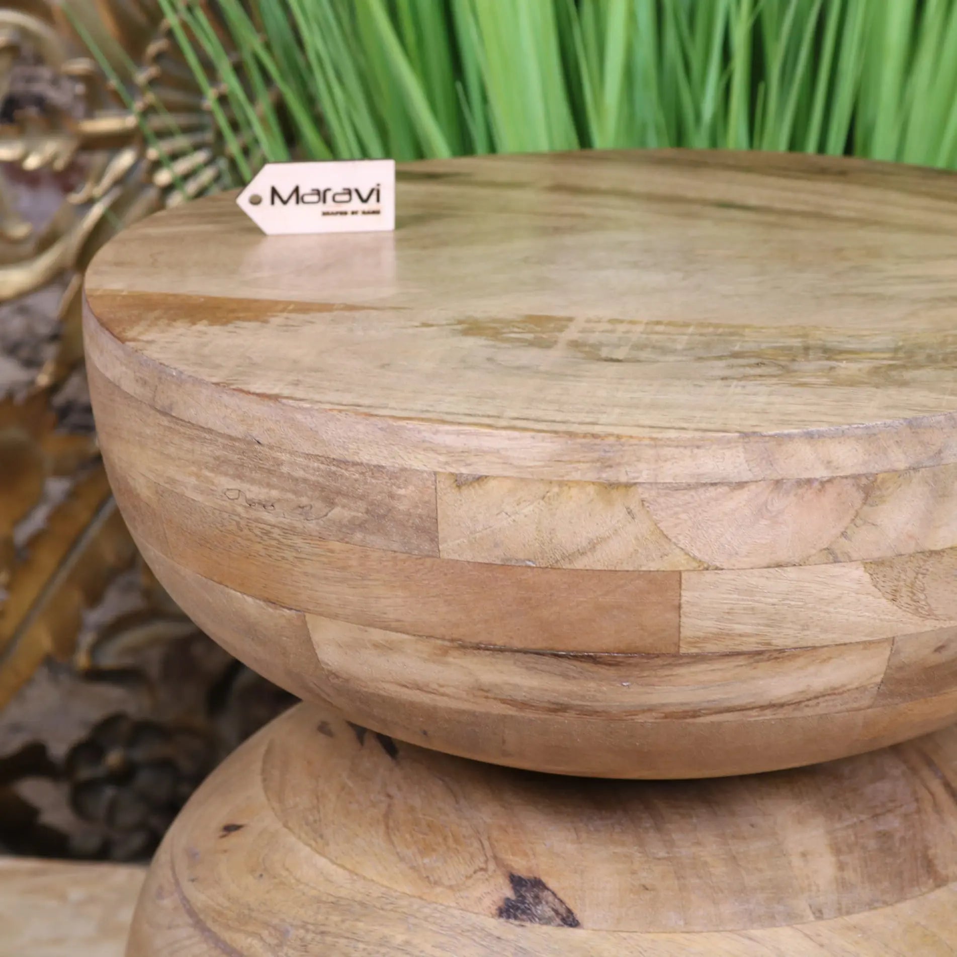 A round light-toned narmada swirl mango wood side table with stacked rustic design and visible wood grain