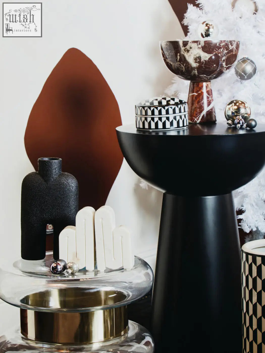 Black marble patterned bowl with tall slender stem and metallic accents paired with white marble bookends
