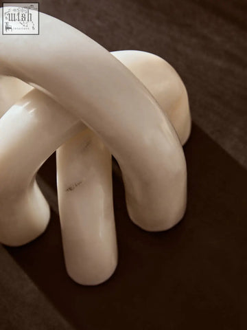 Cream-colored glossy ceramic nason white marble arch decor sculpture with smooth interlocking forms and subtle veining