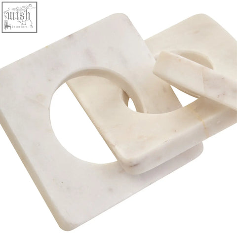 White marble square coasters with circular cutout design complementing the nason white marble three link chain