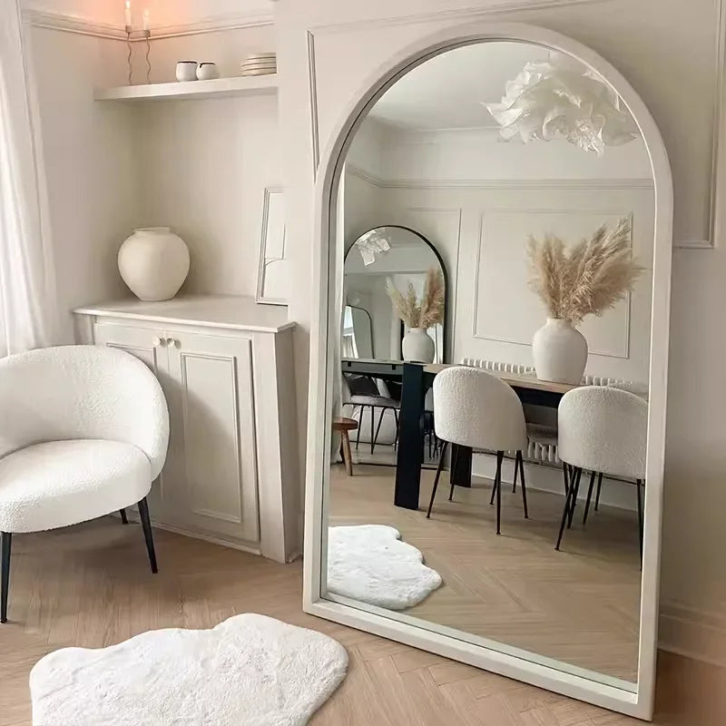 The natsuki mirror is a tall arched mirror with a sleek white frame reflecting elegant room decor