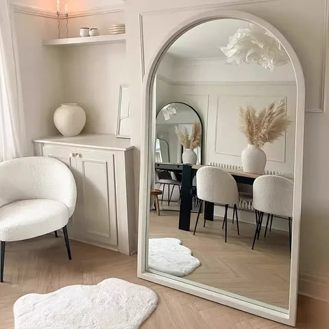 The natsuki mirror is a tall arched mirror with a sleek white frame reflecting elegant room decor