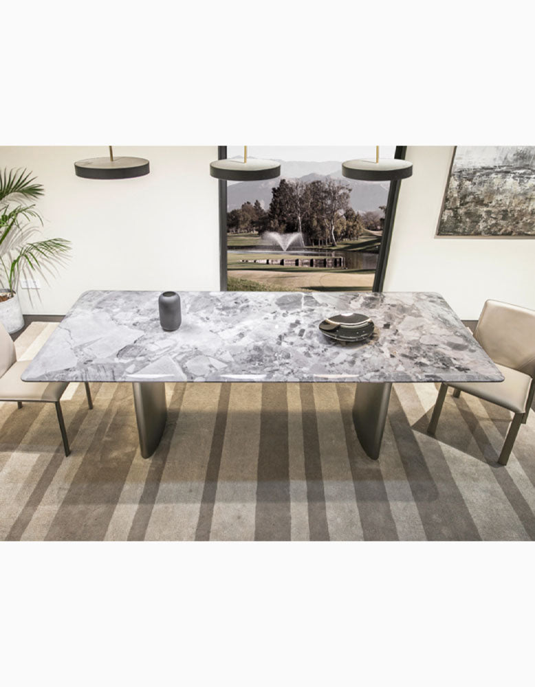 Long rectangular natural marble dining table with sleek metallic legs and gray veined surface perfect for dining areas