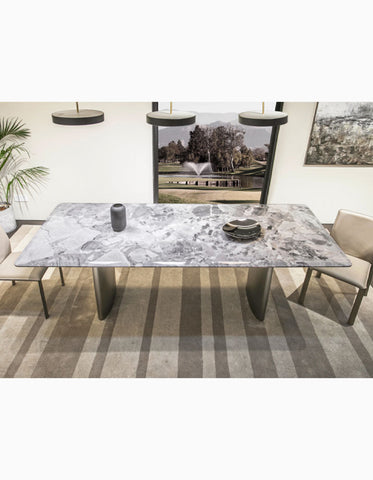 Long rectangular natural marble dining table with sleek metallic legs and gray veined surface perfect for dining areas