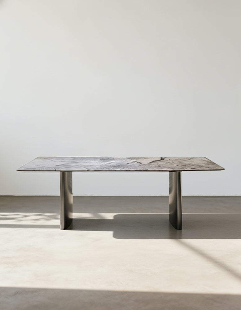 A sleek rectangular natural marble dining table with gray marble top and polished chrome legs perfect for dining rooms