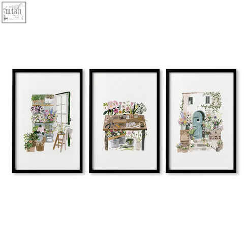 Set of three black-framed nature canvas wall art prints featuring flower shop scenes and botanical illustrations