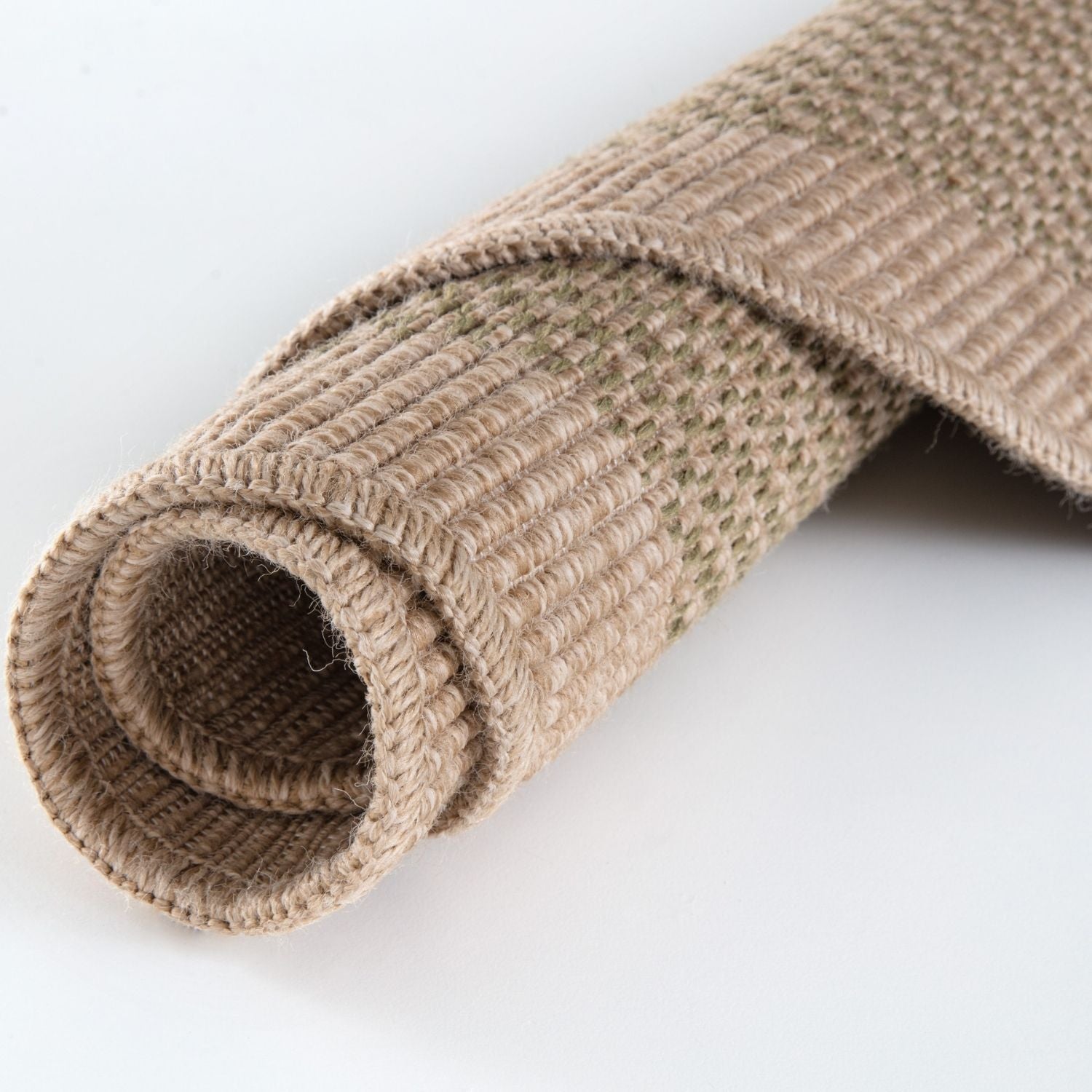 A rolled beige burlap nature outdoor rug with a textured woven fabric surface perfect for outdoor use green model