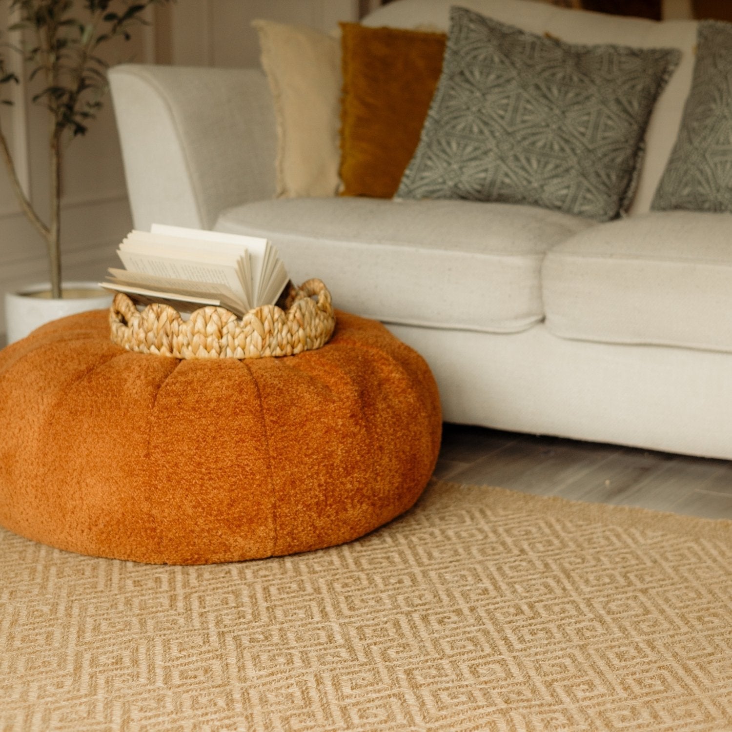 Orange suede pouf with woven basket on a nature outdoor rug neutral perfect for nature outdoor spaces