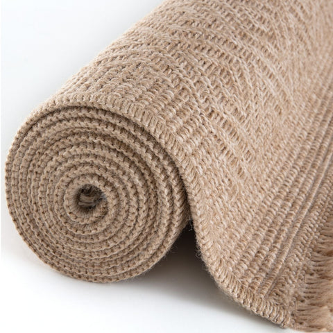 A rolled beige burlap nature outdoor rug with a coarse woven texture perfect as an outdoor rug neutral choice