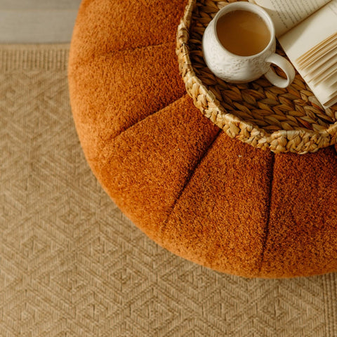 Warm orange plush textured pouf with pumpkin design perfect for complementing a nature outdoor rug neutral setup