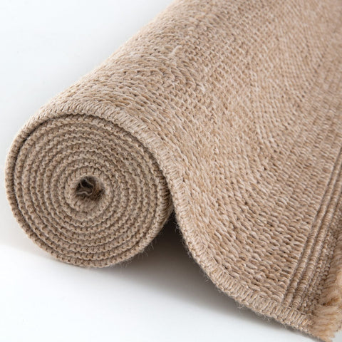A beige textured jute nature outdoor rug rolled neatly on a white surface perfect as an outdoor rug neutral option
