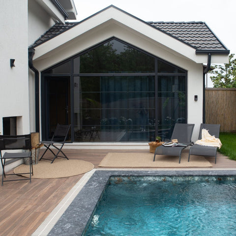 Modern gray lounge chairs with sleek metal frames on a wooden deck featuring nature outdoor rug neutral 5300n