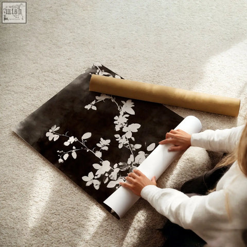 A roll of black and white dark brown-black nature painting art prints with delicate leaf patterns on carpeted floor