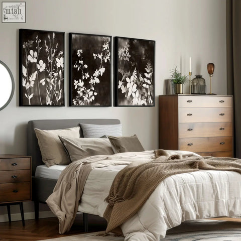 Three black and white botanical art prints with white floral silhouettes in sleek black frames for nature painting decor