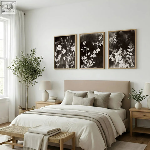 Beige upholstered bed with matching pillows and neutral throw blanket below dark brown black nature painting art prints set of 3