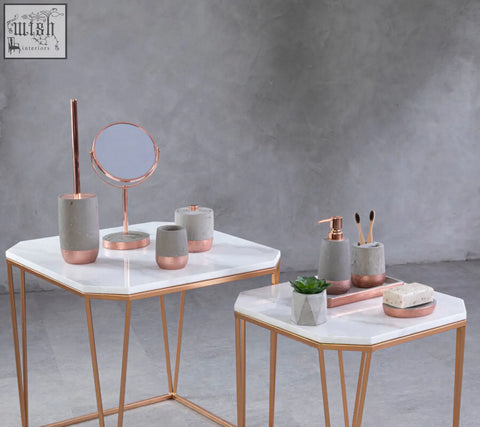 Rose gold finished geometric mirror with circular frame and stand next to neptune concrete effect soap dish