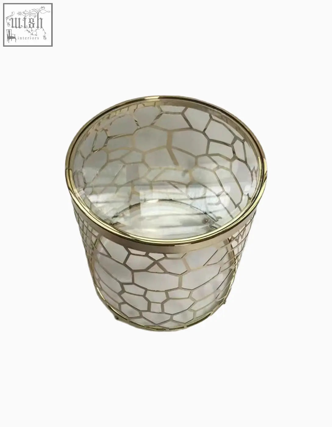 Clear glass candle holder with gold geometric lattice and metallic rim on nested glass side table with sintered stone top