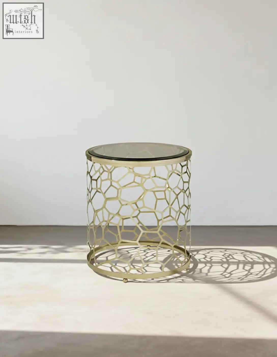 Nested glass side table with gold-toned honeycomb metal frame and clear glass top perfect for modern spaces