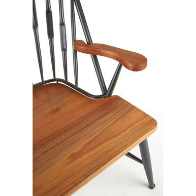 A rustic foundry walnut wood and metal armchair with dark metal frame and curved armrest
