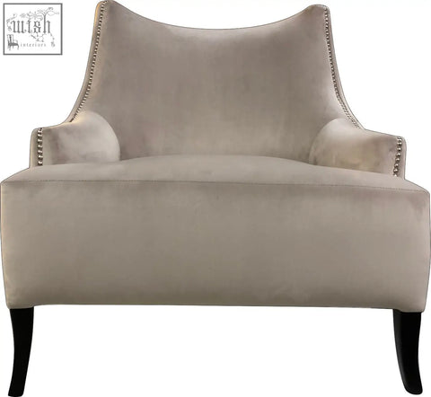 Beige velvet york arm chair with silver nailhead trim and dark wood legs perfect for cozy seating
