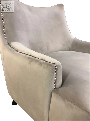 A plush light gray velvet new york arm chair with sleek modern design and silver nailhead trim along the edges