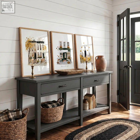 Dark gray console table with two drawers and black metal handles below autumn in new york travel wall art set of 3