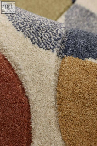A plush newport geometric rug with a bold multicolour geometric pattern in beige rust red mustard yellow and muted blue