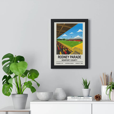 Black-framed poster featuring a vibrant illustration of newport rodney parade stadium with yellow and red seats and green field