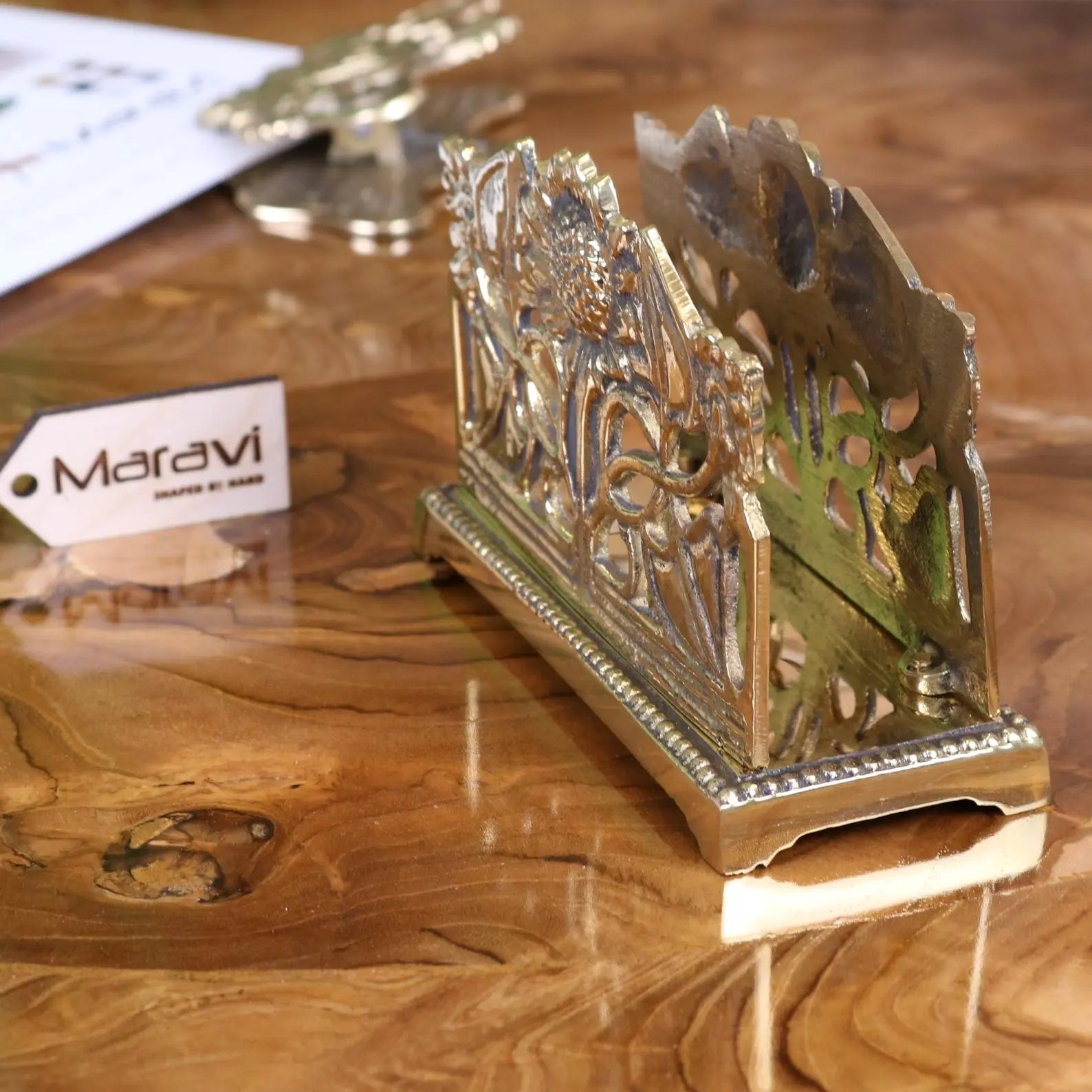Ornate silver-toned metal napkin holder with floral scrollwork design perfect for luxury desk accessories setup