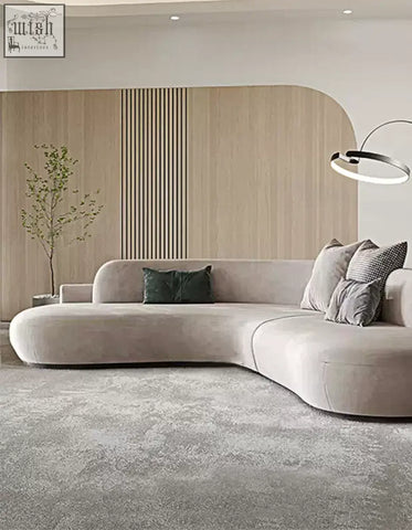 Beige nicosia grey curved three seater sofa with soft suede upholstery and modern minimalist design