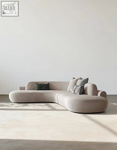 Beige nicosia grey curved suede sectional sofa with soft minimalist design and plush cushions perfect for cozy seating