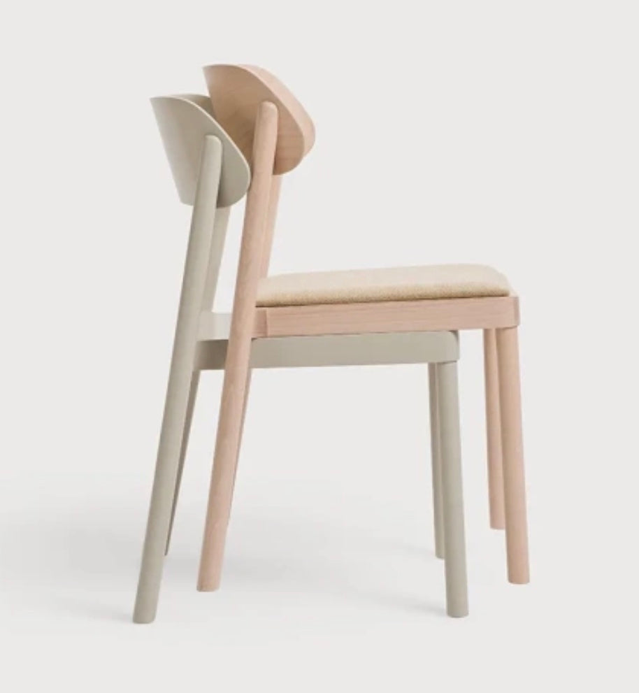 Minimalist nimma chair with light beige upholstered seat and backrest and slender wooden legs in pastel tones