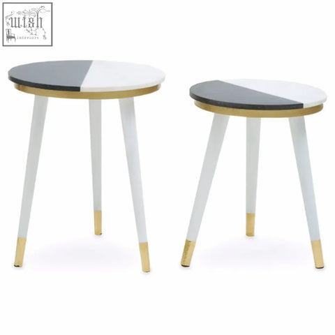 Two minimalist side tables with black and half white marble tops and acacia wood legs with gold trim accents