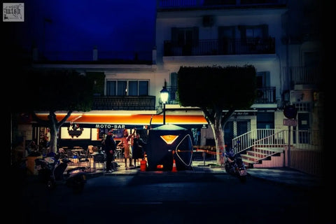 Black and orange illuminated second tent r14s with geometric design outside moto-bar featuring safety pack at night