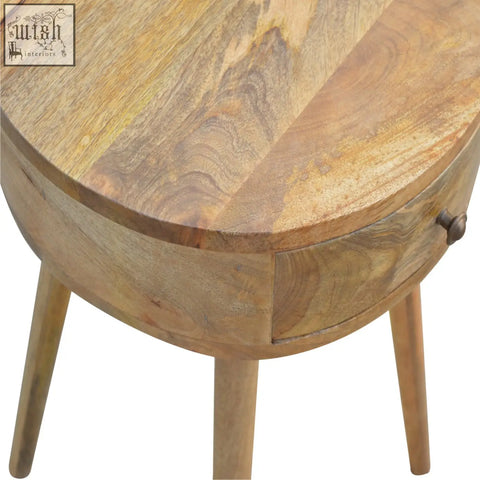 A nordic circular shaped bedside table made of oak mango wood with natural finish and four tapered legs